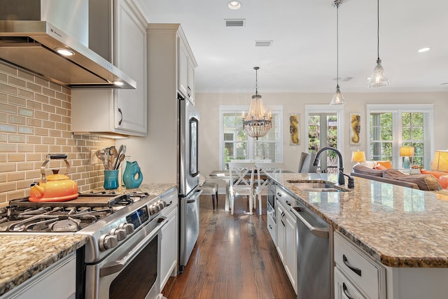 kitchen featuring stainless steel appliances, crown molding, a sink, and wall chimney range hood