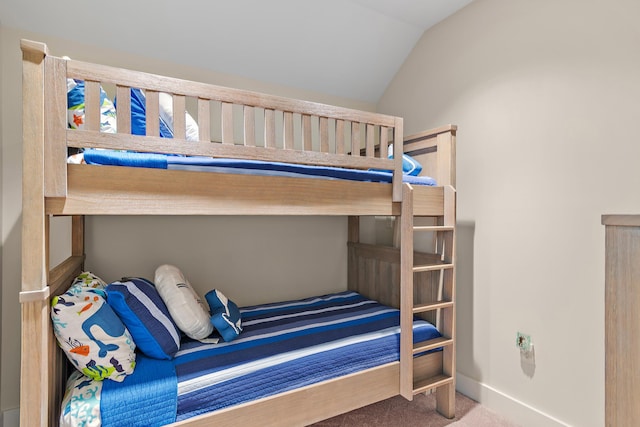 bedroom with carpet flooring, vaulted ceiling, and baseboards