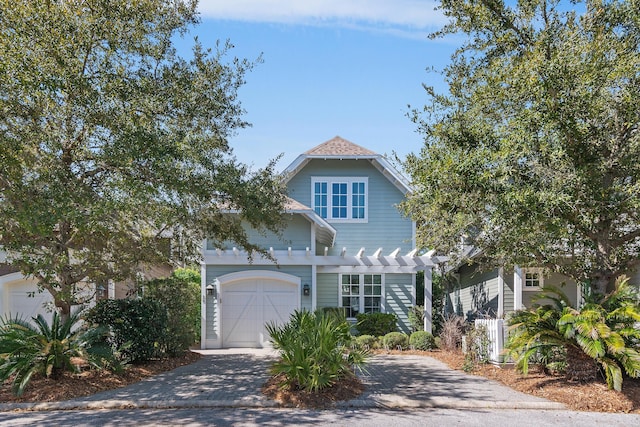 view of front of property with a garage, driveway, and a pergola