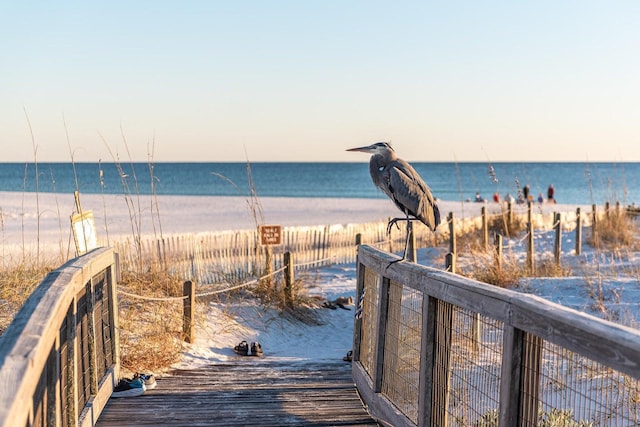 surrounding community with a water view and a beach view