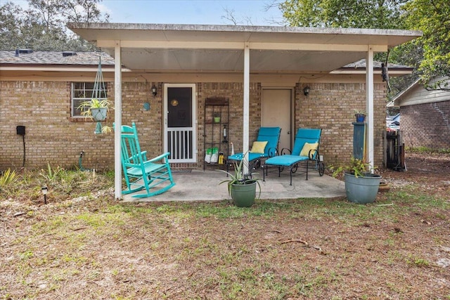 back of property featuring brick siding and a patio