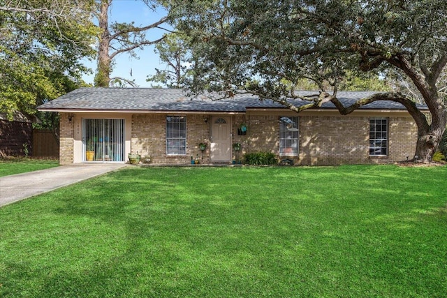 ranch-style house featuring brick siding, fence, and a front lawn