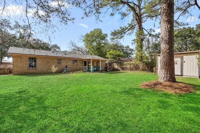 view of yard featuring an outbuilding, fence, and a storage shed