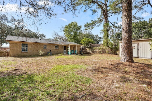 view of yard featuring an outbuilding, fence, and a storage unit