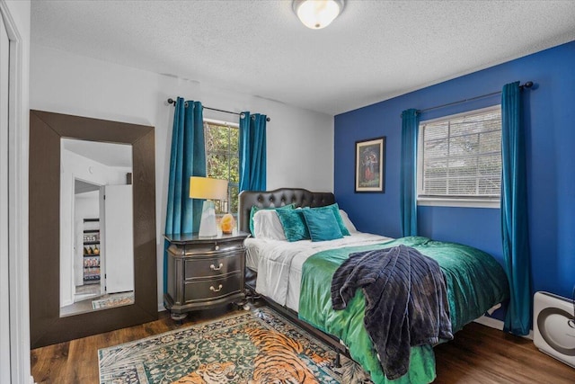 bedroom featuring a textured ceiling and wood finished floors