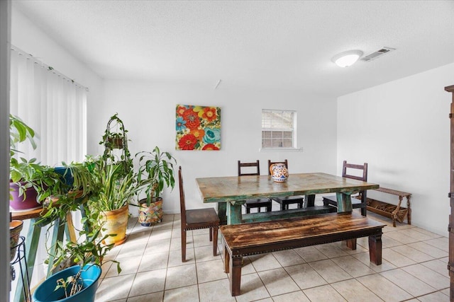 dining room featuring visible vents, a textured ceiling, and light tile patterned floors