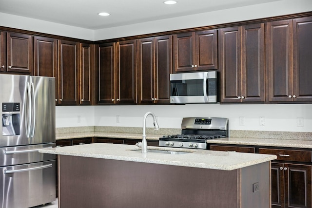 kitchen with dark brown cabinets, an island with sink, recessed lighting, stainless steel appliances, and a sink