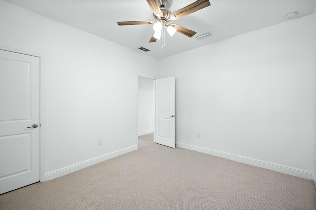 empty room featuring baseboards, visible vents, and light carpet