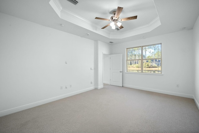 spare room featuring light colored carpet, baseboards, a tray ceiling, and ornamental molding