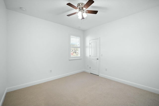 unfurnished room featuring light colored carpet, baseboards, and ceiling fan