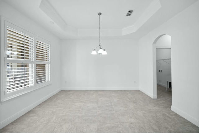 unfurnished dining area featuring visible vents, baseboards, ornamental molding, arched walkways, and a raised ceiling