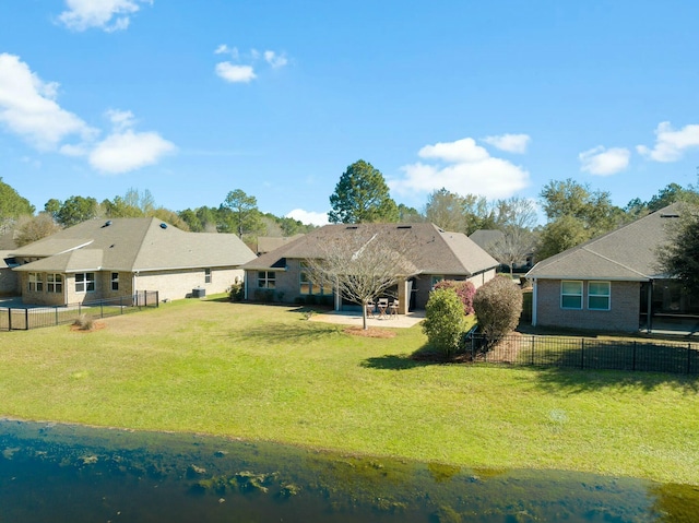 rear view of house with a patio area, a yard, a fenced backyard, and brick siding