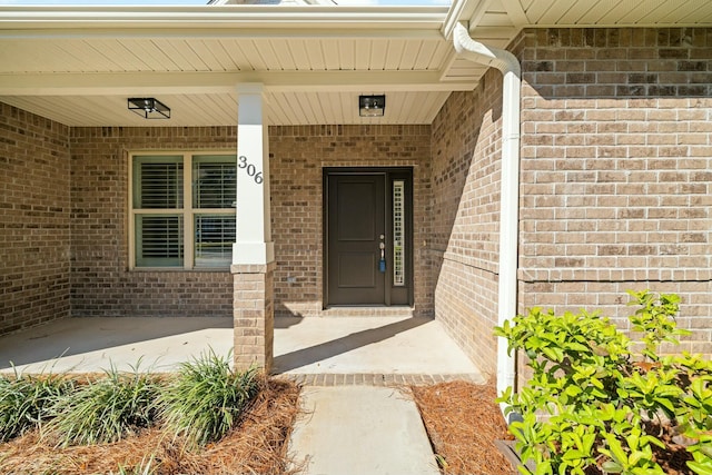 view of exterior entry featuring brick siding