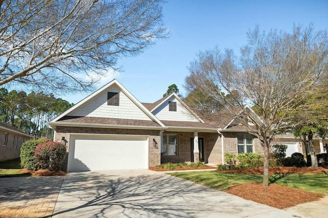 craftsman house featuring brick siding, an attached garage, concrete driveway, and a front yard