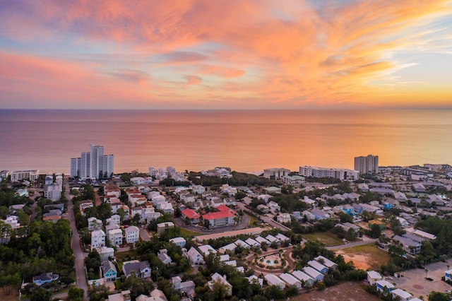 aerial view at dusk featuring a water view and a view of city