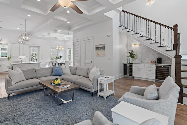 living area featuring wine cooler, coffered ceiling, and wood finished floors