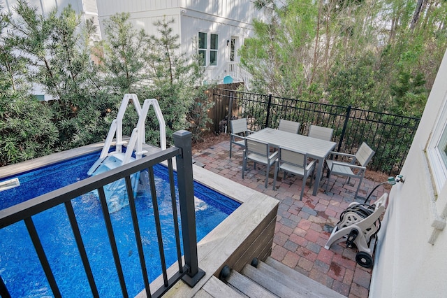 view of swimming pool featuring a fenced in pool, outdoor dining space, and a patio area