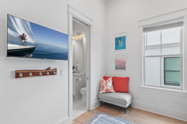 interior space with toilet, wood finished floors, and baseboards