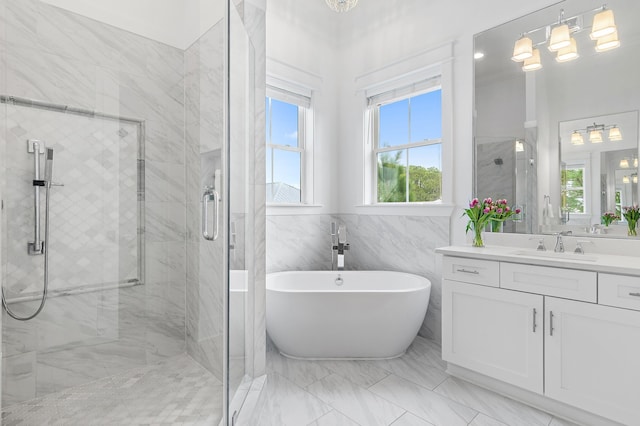 full bathroom with vanity, a freestanding tub, a shower stall, tile walls, and marble finish floor