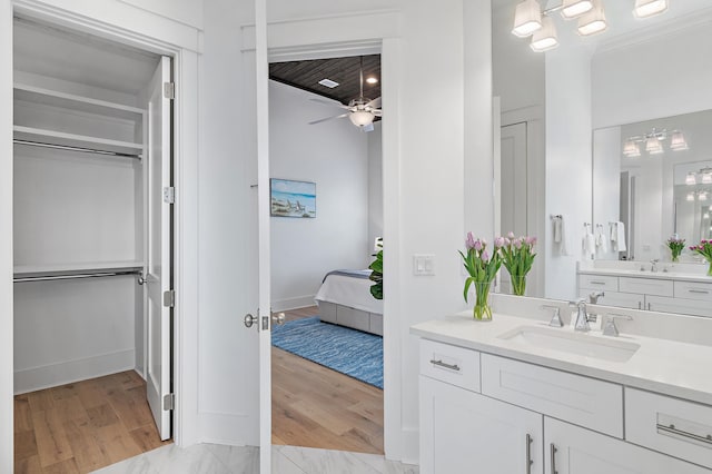 full bath with a ceiling fan, vanity, wood finished floors, and connected bathroom