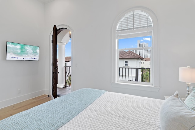 bedroom with baseboards and wood finished floors