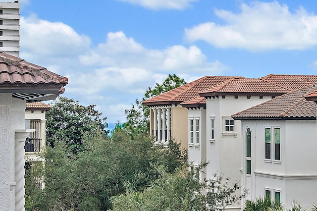 view of side of property with stucco siding and a tile roof