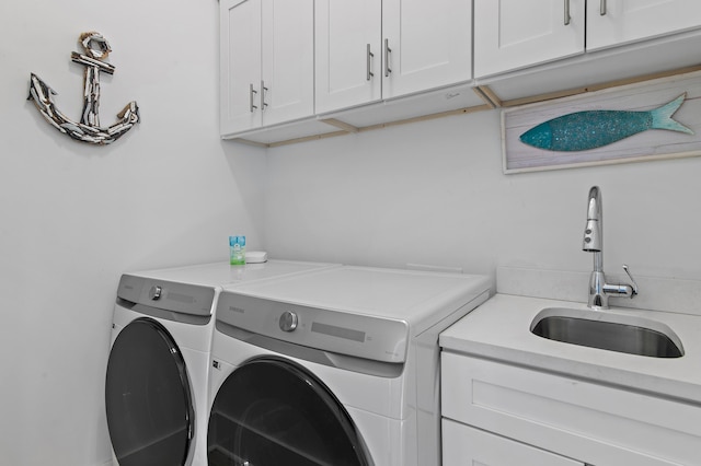 laundry room featuring separate washer and dryer, cabinet space, and a sink