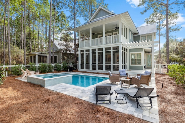 back of house featuring a ceiling fan, a sunroom, a patio area, a balcony, and a fire pit