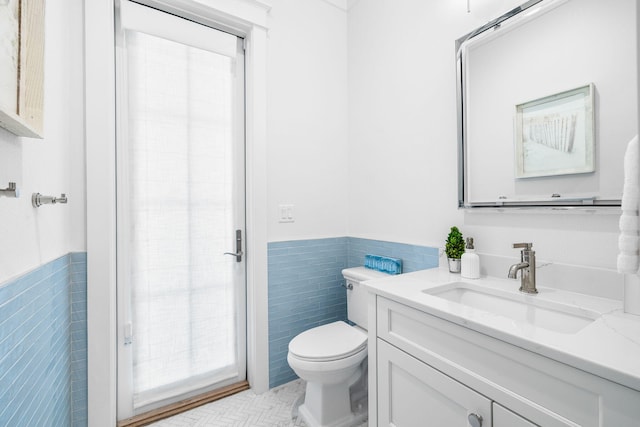 44 Thicket Cir, Santa Rosa Beach, FL 32459 - bathroom with tile walls, plenty of natural light, wainscoting, toilet, and vanity