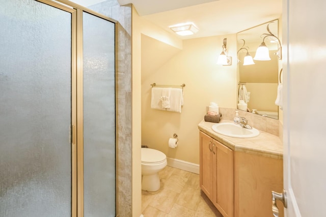 bathroom with toilet, a shower stall, vanity, and baseboards