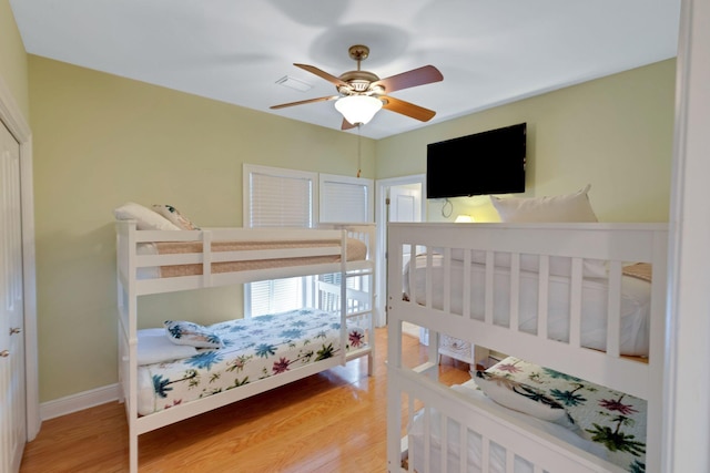 bedroom featuring visible vents, wood finished floors, a ceiling fan, and baseboards