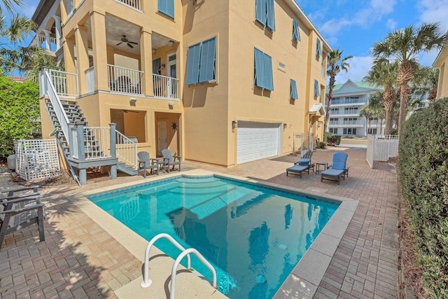 pool featuring fence, stairway, and a patio