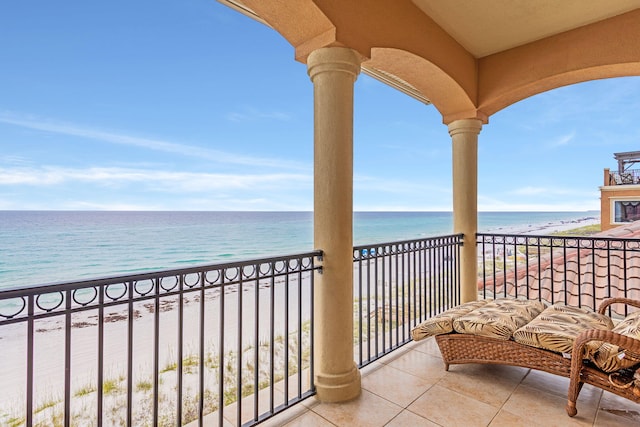 balcony featuring a beach view and a water view