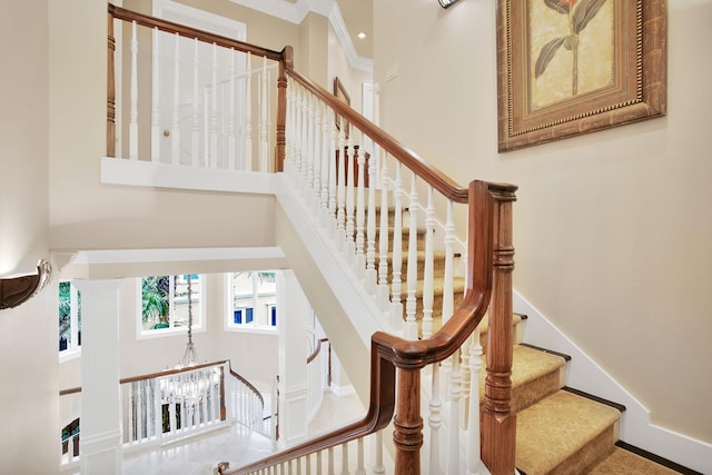 staircase featuring a high ceiling and baseboards