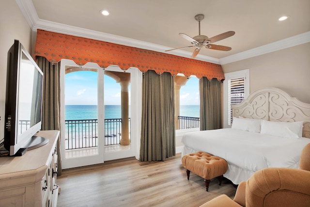 bedroom featuring access to outside, light wood-style flooring, a water view, and ornamental molding