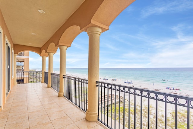 balcony featuring a water view and a beach view