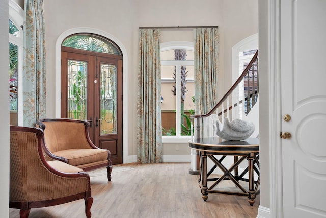 entrance foyer featuring baseboards, stairs, and light wood finished floors