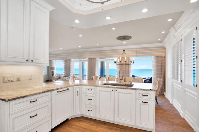 kitchen featuring plenty of natural light, ornamental molding, and a sink