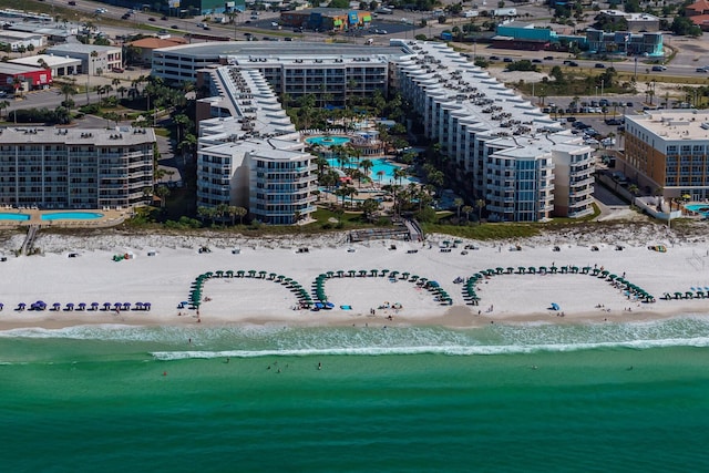 drone / aerial view with a city view, a beach view, and a water view