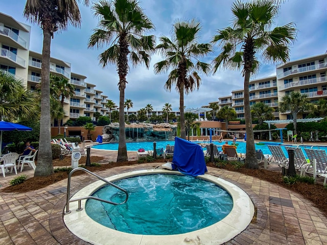 pool with a hot tub and a patio