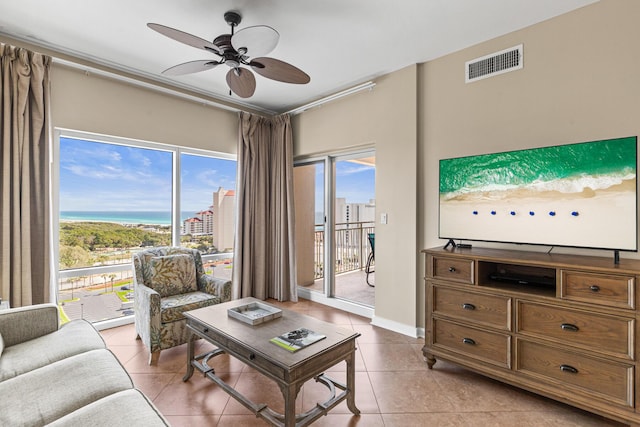 living room featuring ceiling fan, visible vents, a wealth of natural light, and light tile patterned flooring