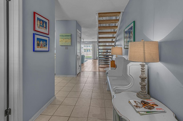 hallway featuring light tile patterned floors and baseboards