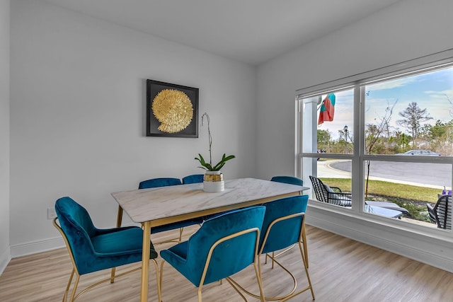 dining space with light wood-style flooring and baseboards