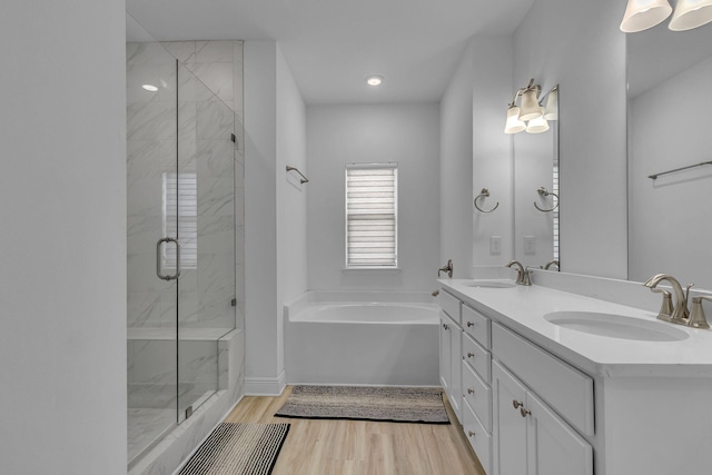 bathroom with a stall shower, a sink, and wood finished floors