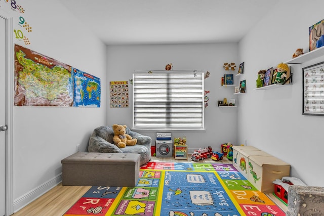 recreation room featuring wood finished floors and baseboards