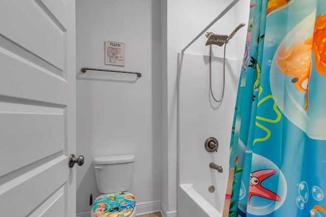 bathroom featuring toilet, baseboards, and shower / bath combination with curtain