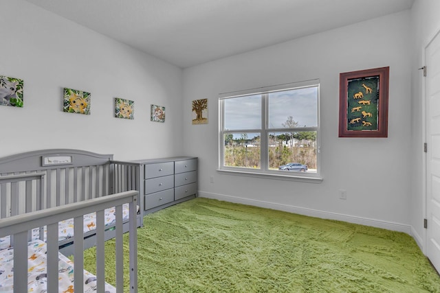 bedroom featuring a crib, carpet, and baseboards