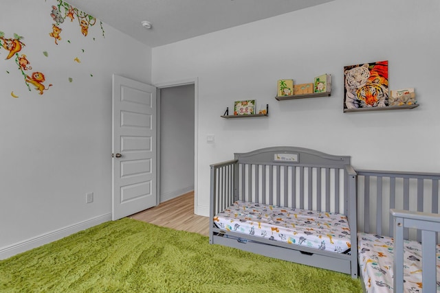 bedroom with a crib and baseboards