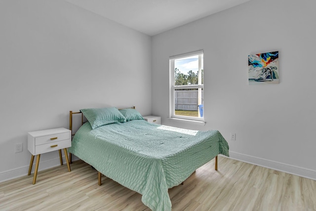 bedroom featuring wood finished floors and baseboards