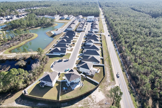 aerial view featuring a water view, a wooded view, and a residential view